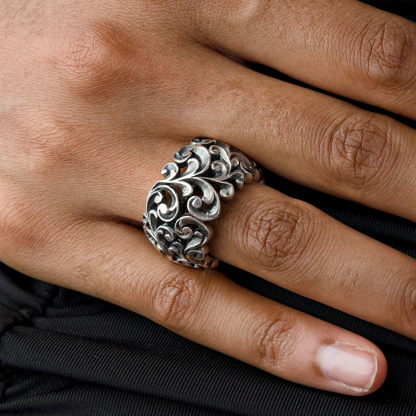 Mujer luciendo el anillo ancho de plata Maria e Luisa, resaltando su diseño arquitectónico y el brillo de la textura grabada.