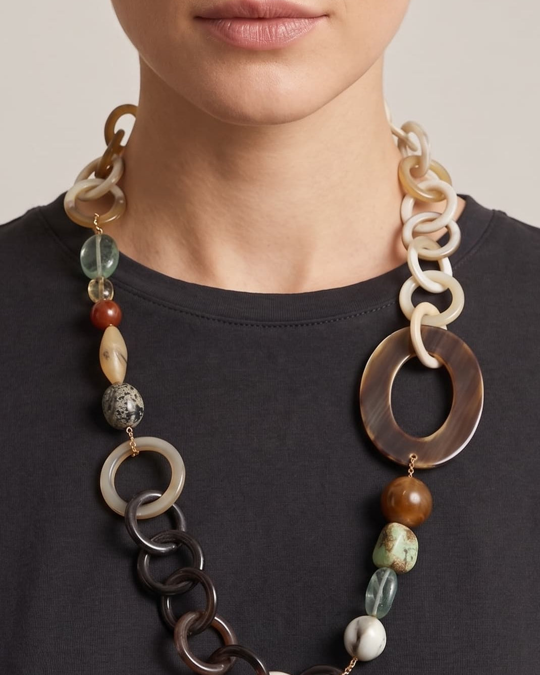 Mujer luciendo el collar Amlé, resaltando la asimetría del diseño y la mezcla de piedras naturales sobre un top oscuro.