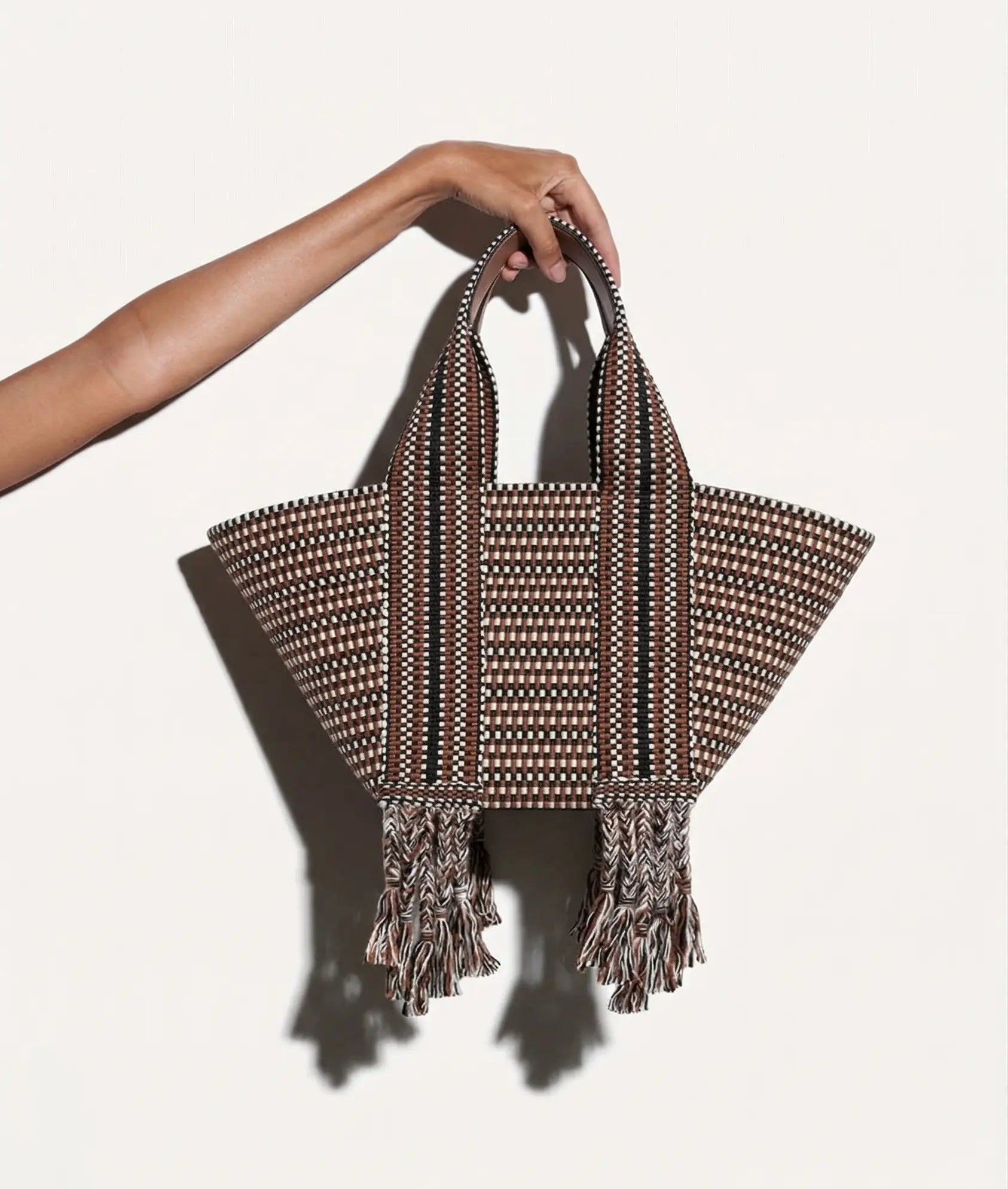 Bolso Amambaih Chulo Small Tierra mostrado en la mano para apreciar su tamaño y diseño.