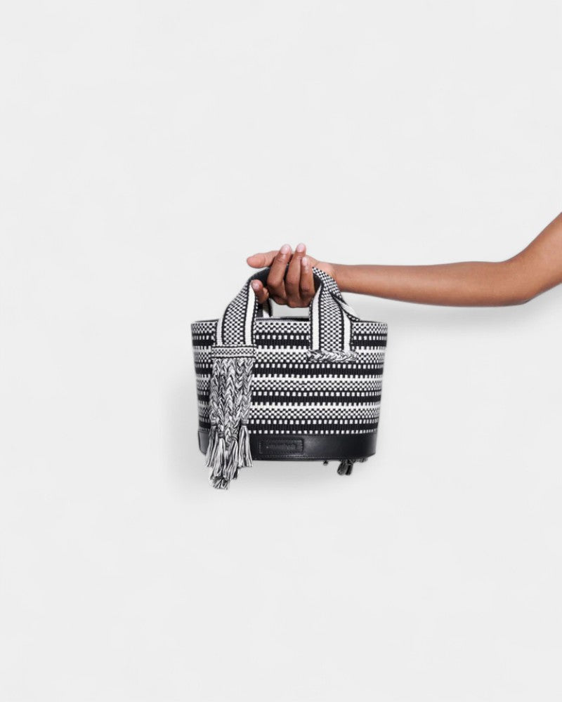 Bolso Tutu Small de Amambaih mostrado en la mano para apreciar su tamaño compacto y diseño artesanal.