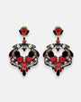 Par de pendientes largos Dublos estilo "statement" con mosaico de cristales en rojo y negro sobre fondo neutro.
