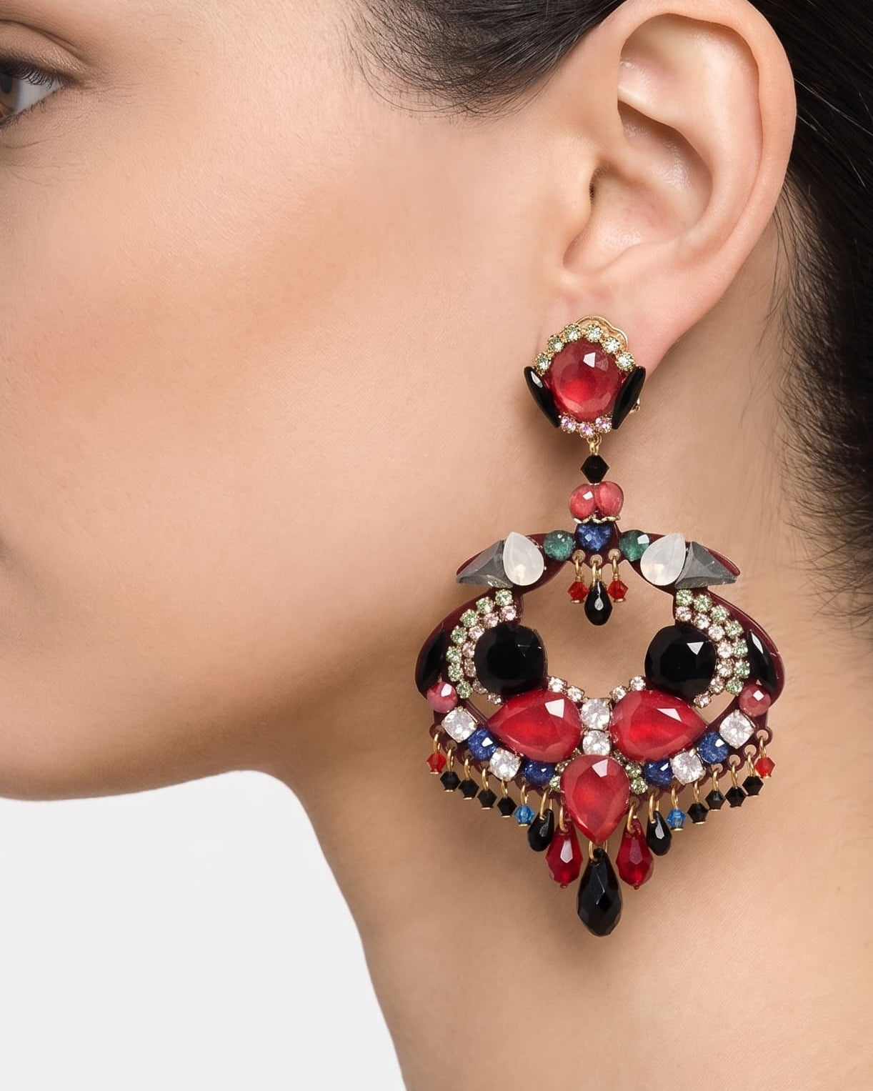 Primer plano de perfil de mujer luciendo los pendientes Dublos, resaltando la forma orgánica y el brillo de los cristales rojos.