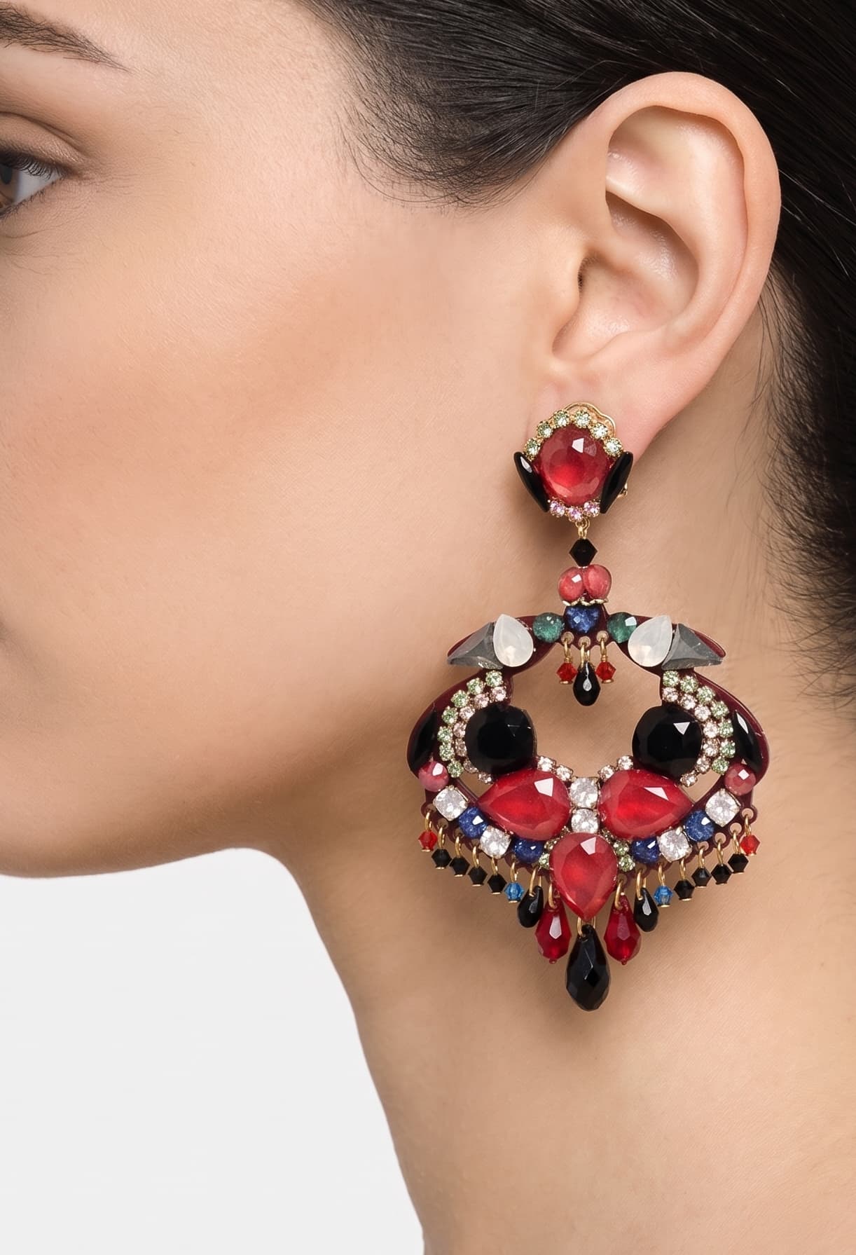 Primer plano de perfil de mujer luciendo los pendientes Dublos, resaltando la forma orgánica y el brillo de los cristales rojos.