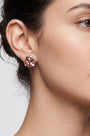 Mujer luciendo los pendientes Bohemme Peach Bloom, resaltando el brillo cálido y el diseño floral en el lóbulo.