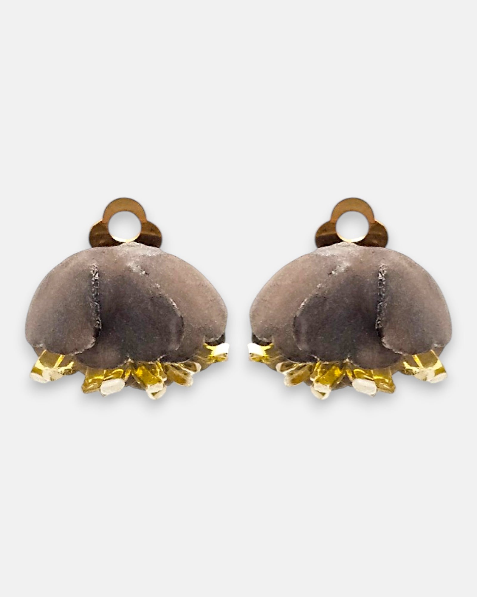 Pareja de pendientes de pinza en forma de concha marina de Ciléa Paris, mostrando su color azul marino satinado y sus detalles en tono crema.