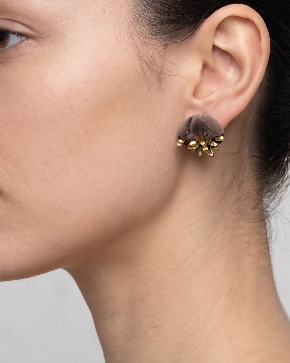 Vista de perfil de los pendientes de concha azul de Ciléa Paris colocados en una modelo, detallando su tamaño compacto y cómo asientan sobre el lóbulo.