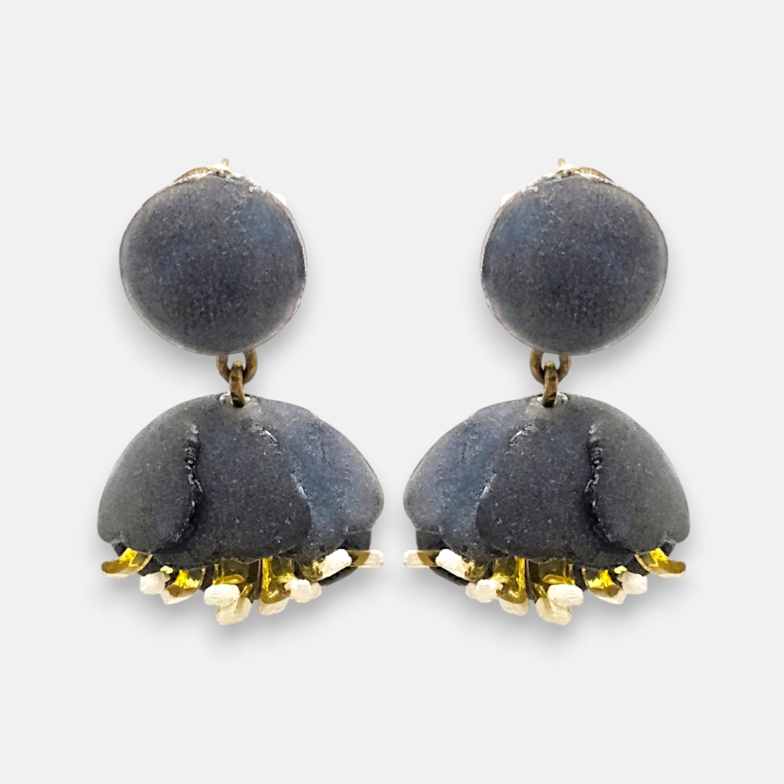 Pareja de pendientes en forma de concha marina de Ciléa Paris, mostrando su color rosa pastel satinado y sus detalles texturizados en tono crema.