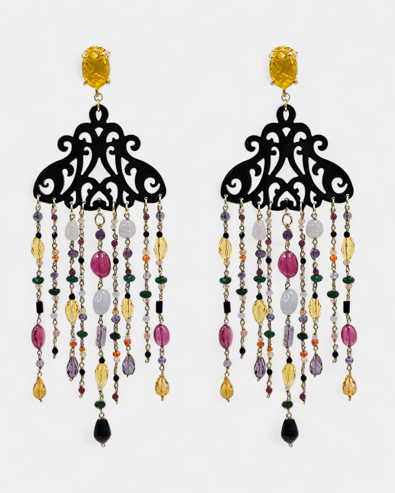 Pendientes largos Amlé de cuerno negro calado con cascada de piedras naturales multicolores sobre fondo blanco.