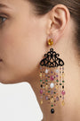 Mujer luciendo los pendientes Amlé de estilo italiano, resaltando el movimiento de las gemas y el detalle del cuerno.