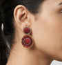 Mujer luciendo los pendientes Cretonne Scarlet, resaltando su tamaño ideal y el brillo del cristal sobre el rostro.