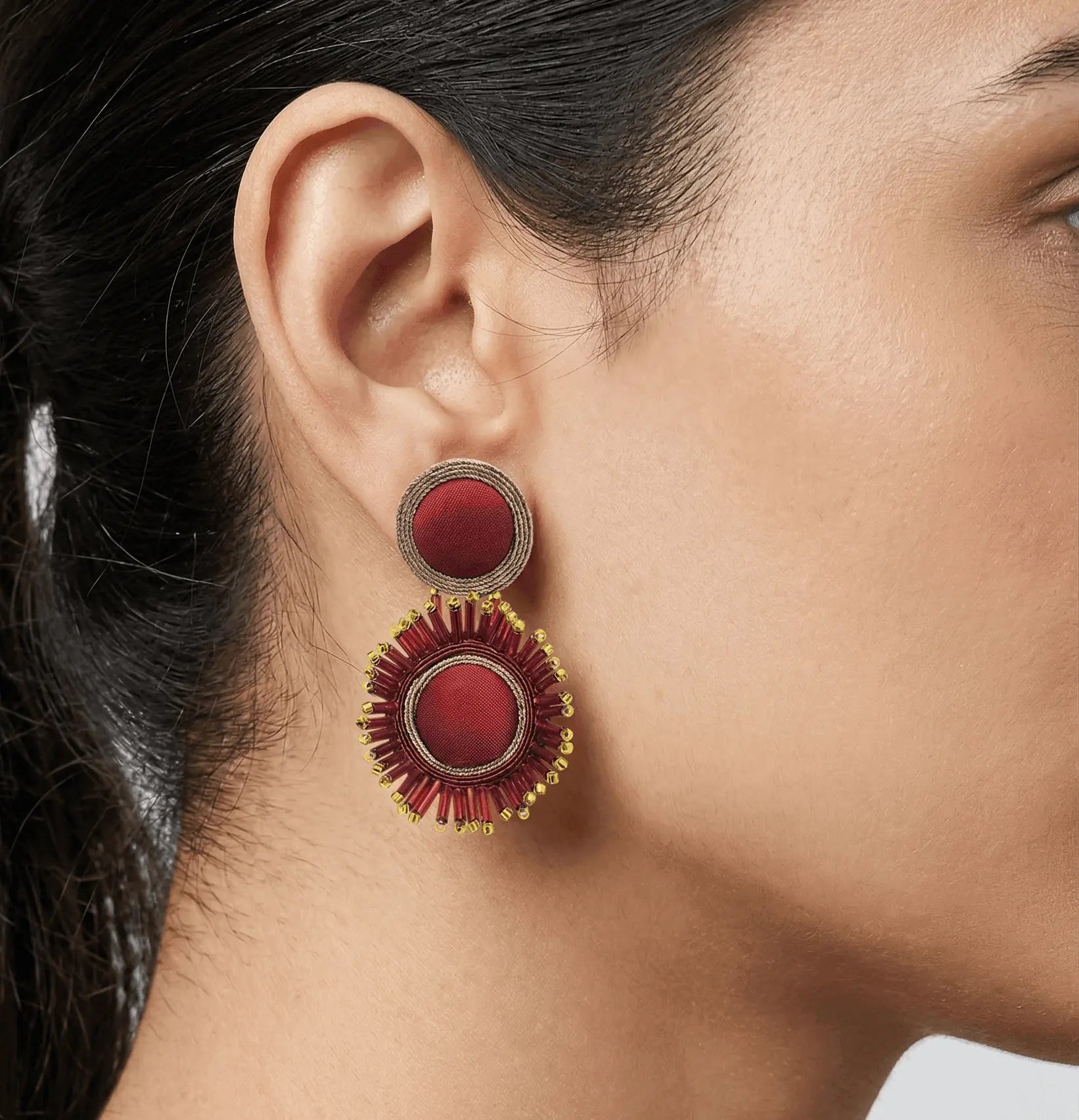 Mujer luciendo los pendientes Cretonne Scarlet, resaltando su tamaño ideal y el brillo del cristal sobre el rostro.