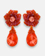Pareja de pendientes de fiesta grandes Flor de Granada de Dublos, mostrando su botón superior de flor naranja mandarina y su gran lágrima facetada coral.