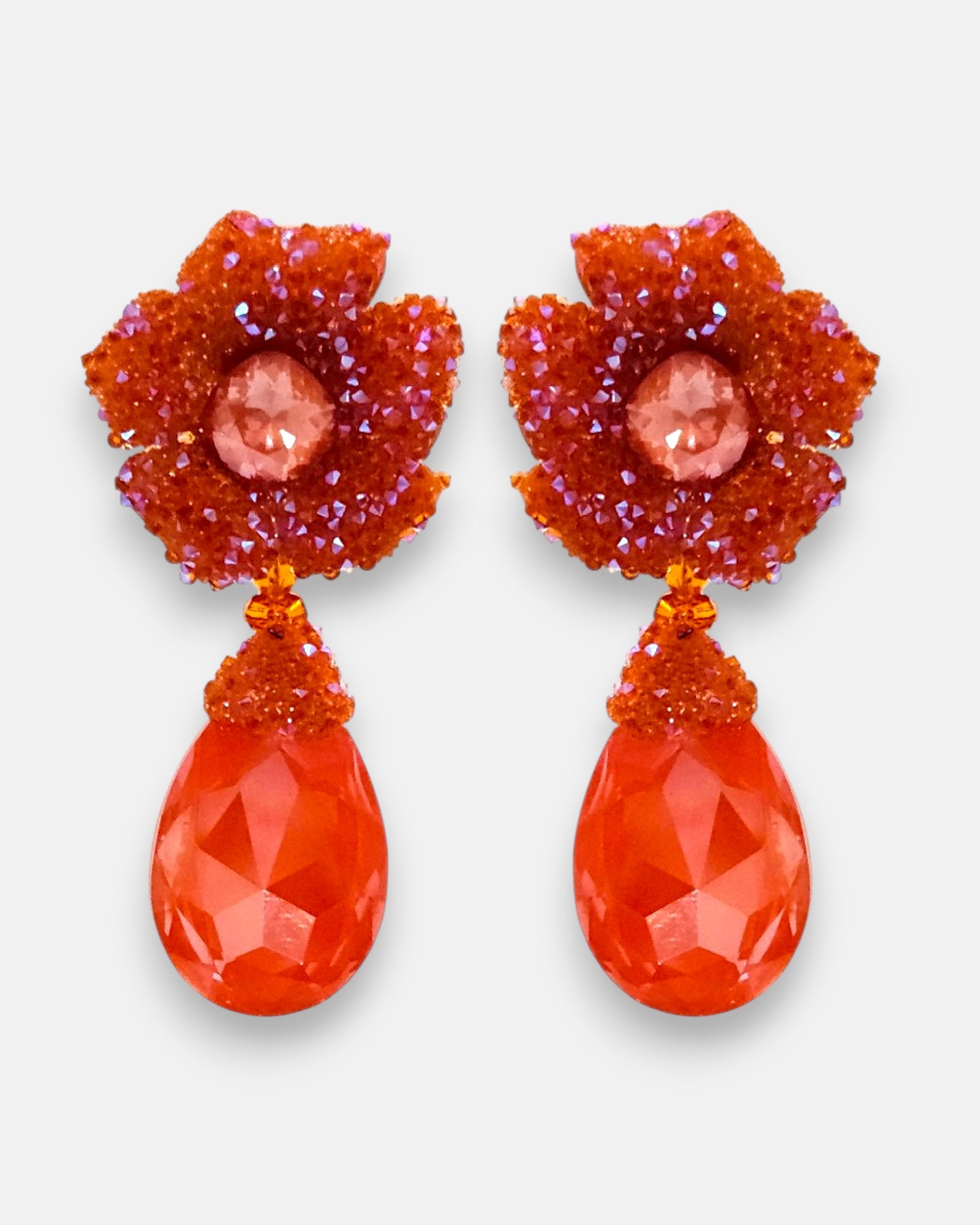Pareja de pendientes de fiesta grandes Flor de Granada de Dublos, mostrando su botón superior de flor naranja mandarina y su gran lágrima facetada coral.