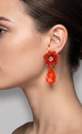 Vista de perfil de un maxipendiente colgante naranja de Dublos colocado en una modelo, detallando la caída y el volumen de la lágrima de cristal.