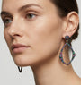 Mujer luciendo los pendientes Bohemme Musa, resaltando su diseño orgánico y el brillo tricolor de las piedras.