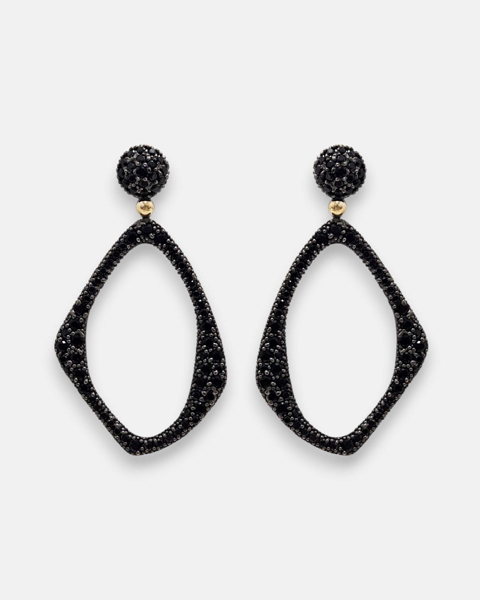 Pareja de pendientes maxi Bohemme Midnight Aura con silueta geométrica y piedras negras sobre fondo blanco.