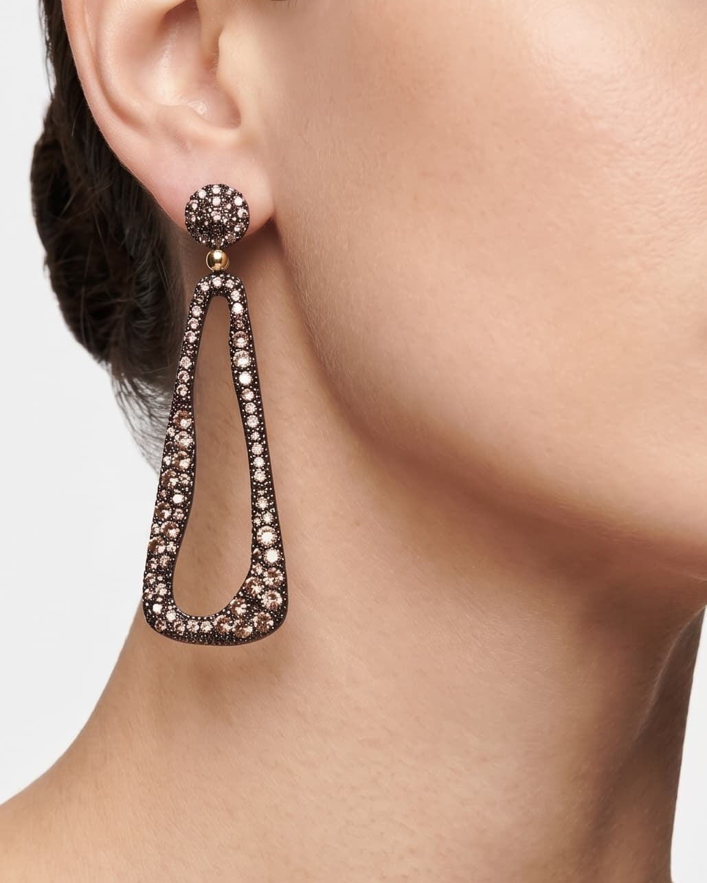 Mujer luciendo los pendientes largos Bohemme Ethereal, destacando su silueta estilizada y brillo cálido.