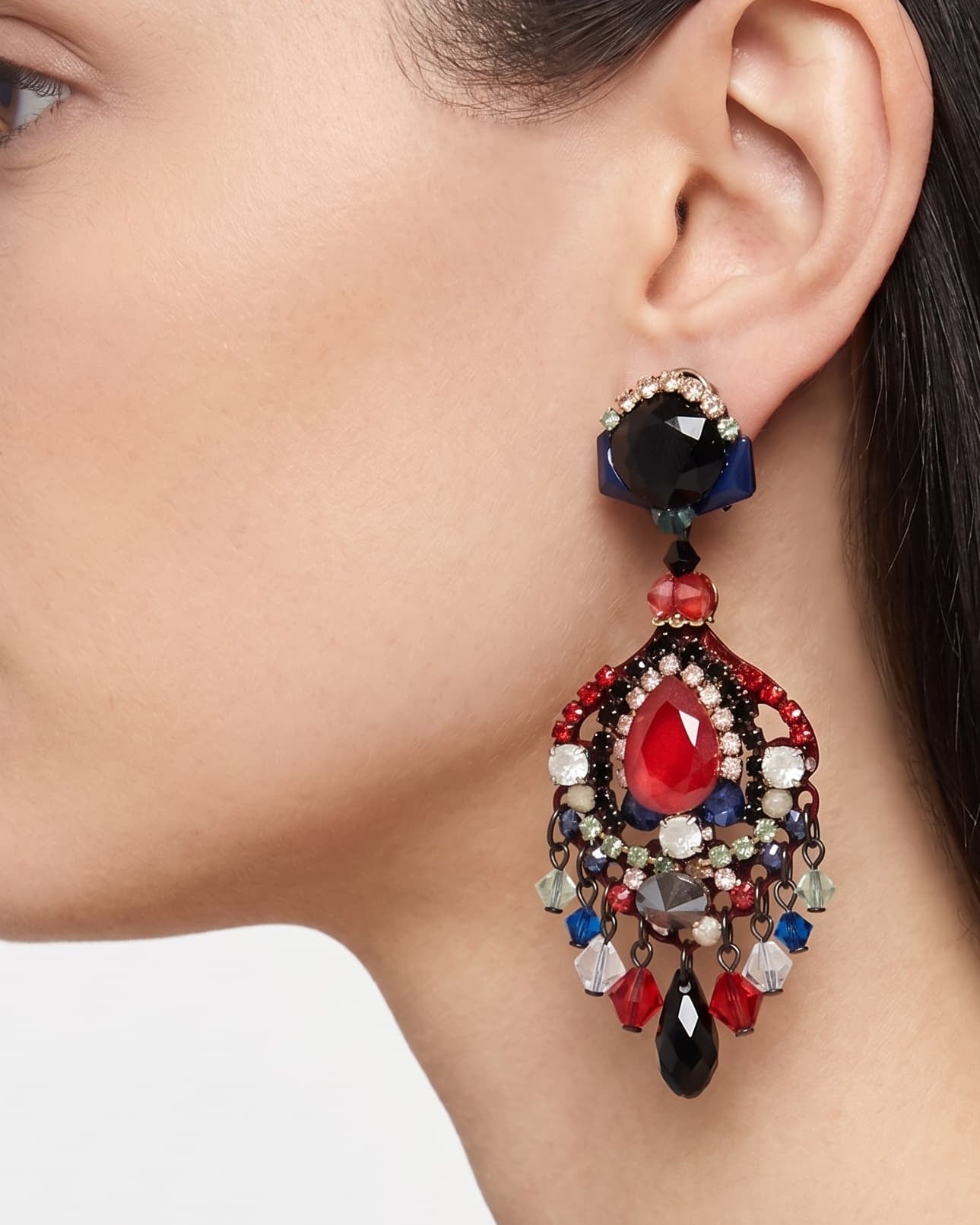 Primer plano de perfil de mujer luciendo los pendientes Dublos, resaltando la forma de lágrima y el brillo intenso del cristal rojo central.