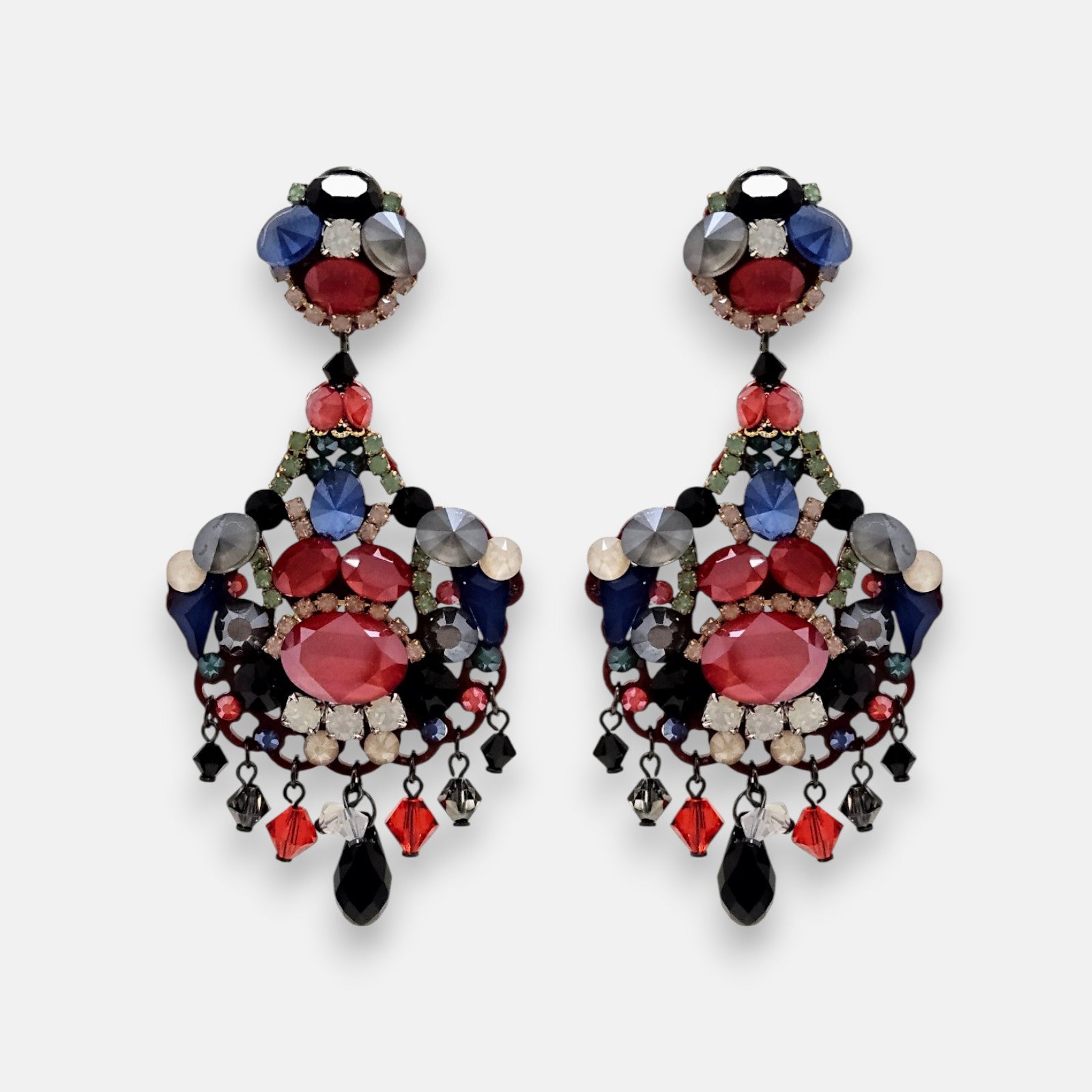 Par de pendientes largos Dublos estilo "chandelier" con mosaico de cristales en rojo, azul y tonos ahumados sobre fondo neutro.