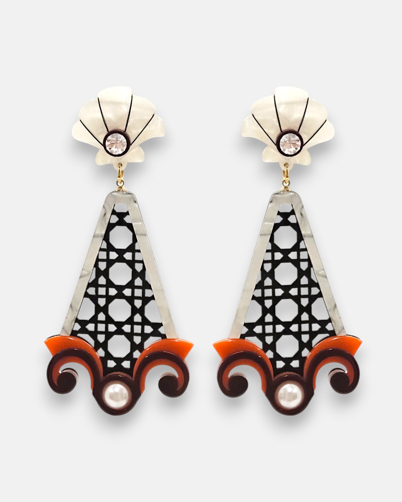 Pareja de pendientes grandes de Gissa Bicalho con cuerpo calado negro tipo rejilla cannage, base de volutas naranja y marrón con perla, y botón superior nácar con cristal.