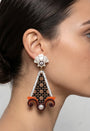 Vista de perfil de los maxi pendientes de acrílico de Gissa Bicalho colocados en una modelo, detallando su caída tridimensional de estilo arquitectónico y su gran escala.