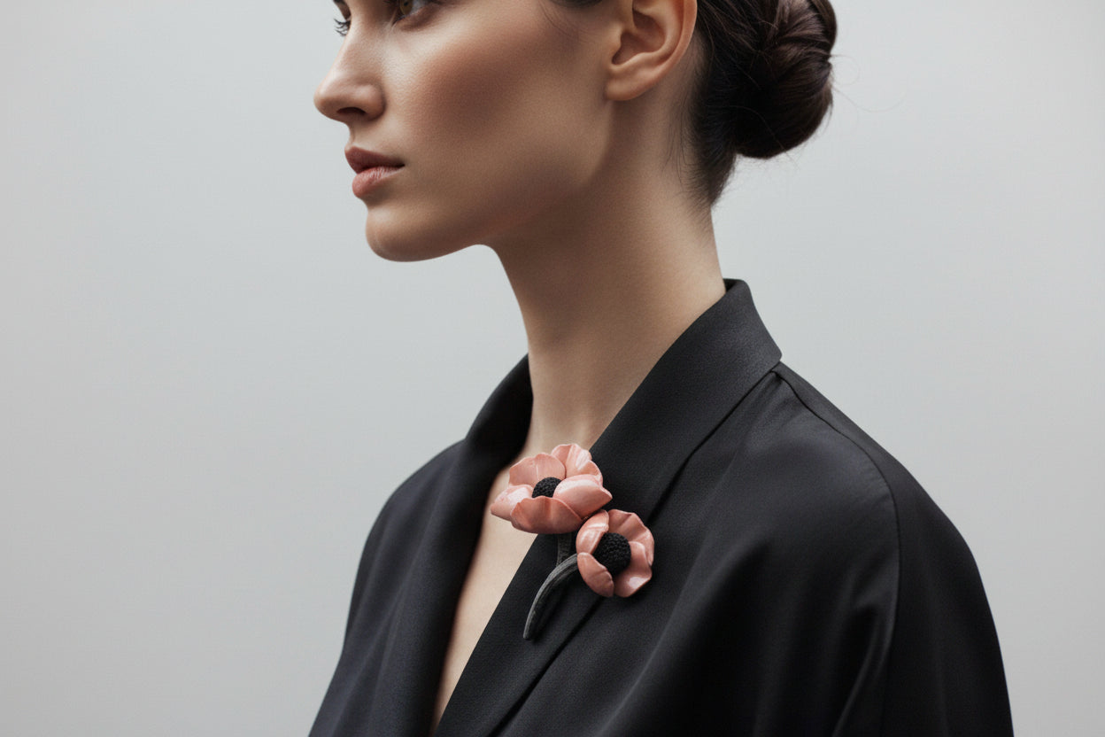 Modelo luciendo broche de flores grandes sobre una chaqueta azul vibrante."