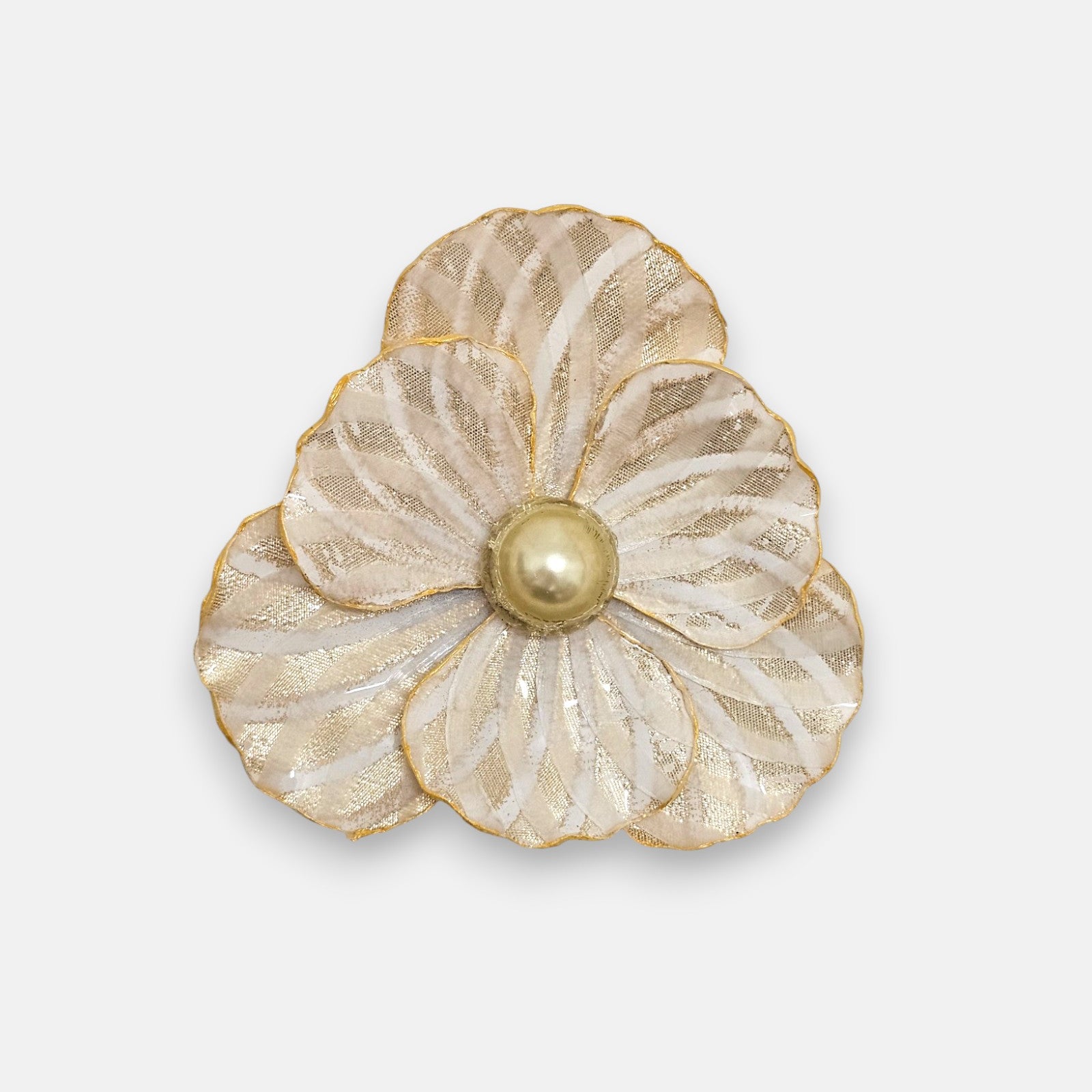 Gran broche maxi en forma de flor camelia de Ciléa Paris, mostrando sus pétalos crema nacarados con rayas doradas y su gran centro perlado champán.