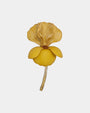 Broche botánico de color amarillo mostaza con pétalos superiores ondulados y tallo dorado sobre fondo blanco.