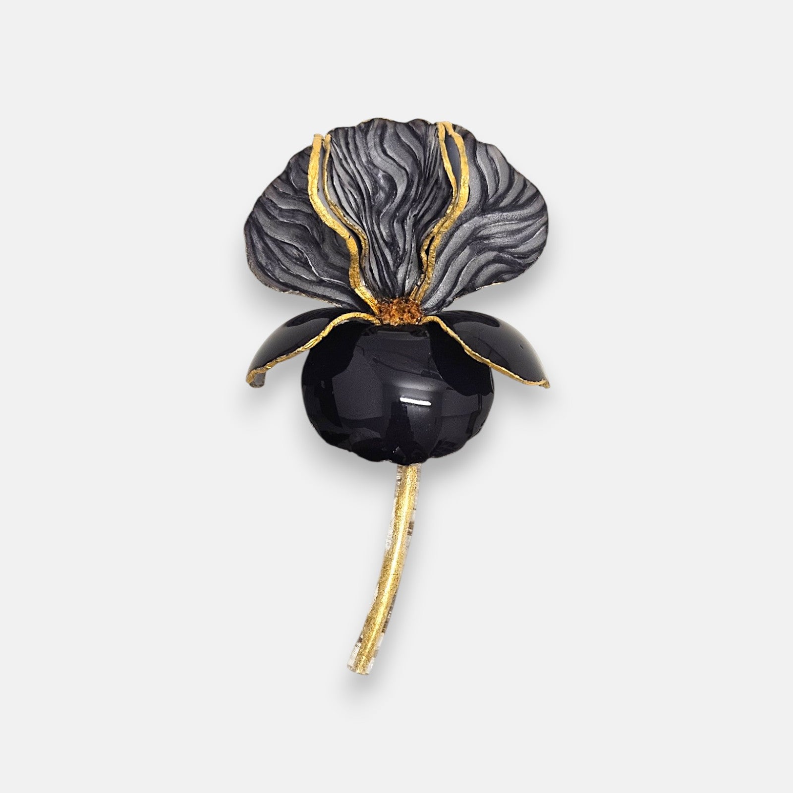Broche de diseño francés en forma de flor iris de Ciléa Paris, mostrando su gran pétalo negro esmaltado, corola superior gris texturizada y detalles dorados.