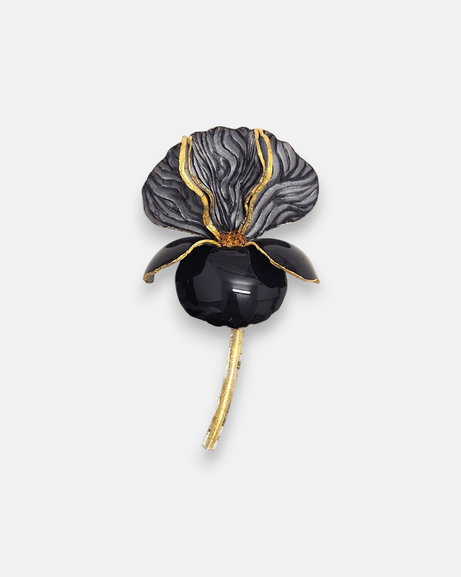 Broche de diseño francés en forma de flor iris de Ciléa Paris, mostrando su gran pétalo negro esmaltado, corola superior gris texturizada y detalles dorados.