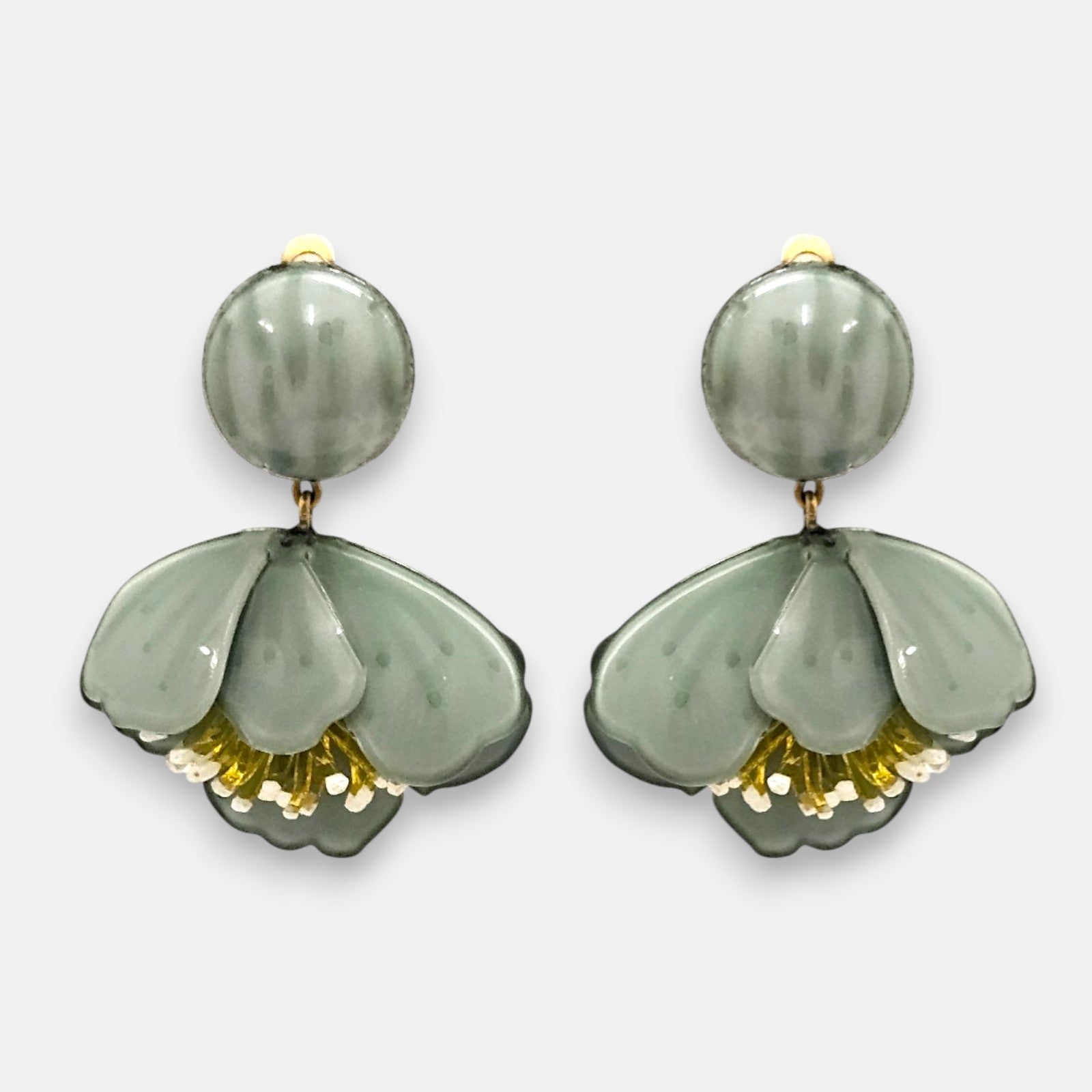 Pareja de pendientes grandes en forma de flor acampanada de Ciléa Paris, mostrando sus pétalos verdes satinados, centro amarillo metalizado y botón superior.