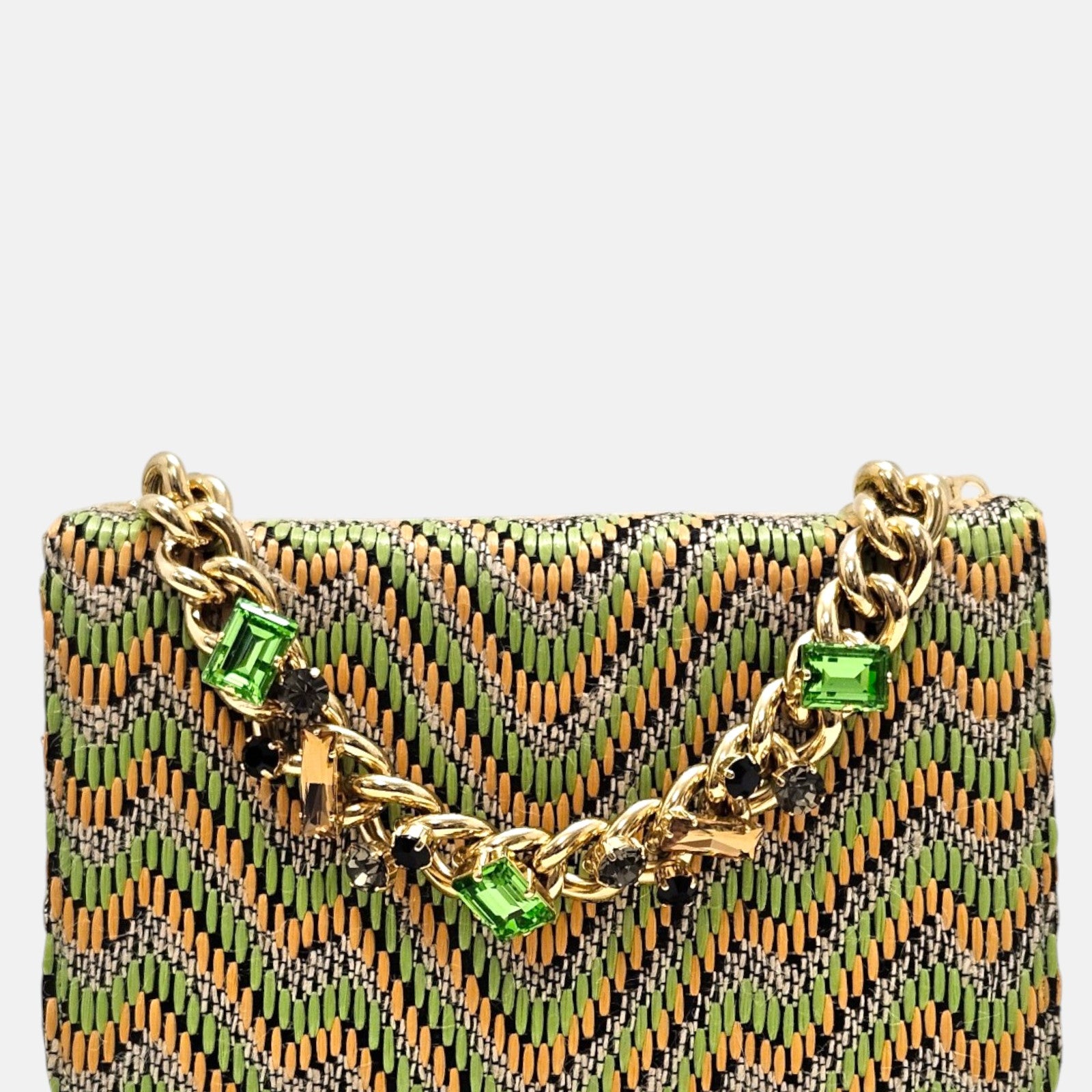 parte delantera de un bolso estructurado de Emanuela Caruso con estampado chevron en tonos verdes y beige, decorado con una espectacular cadena dorada con grandes cristales verdes y oscuros engastados.