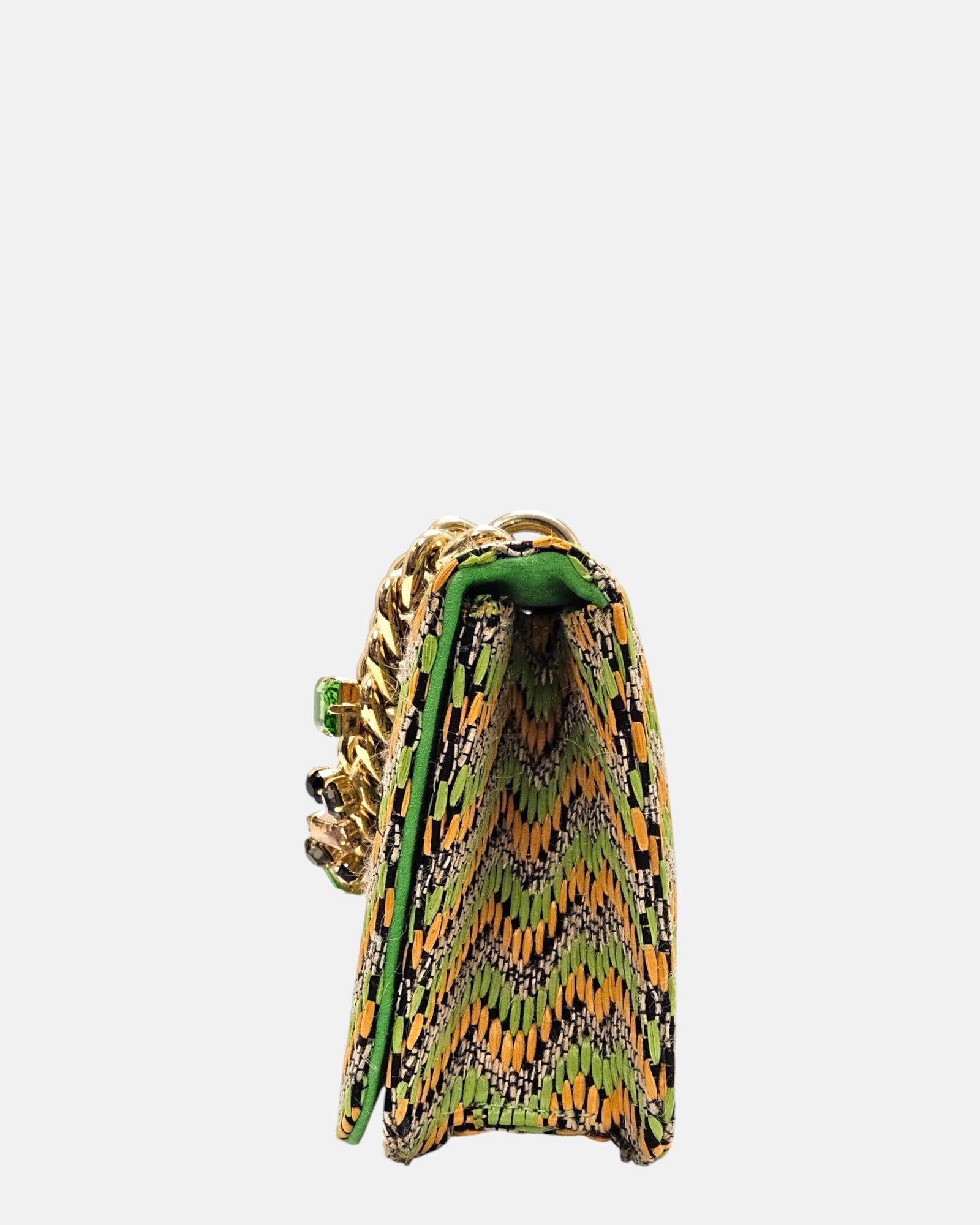 perspectiva de perfil del bolso italiano, revelando su fuelle estructurado de 6 cm de ancho, el doblez de la solapa superior y los bordes rematados en piel color verde neón.