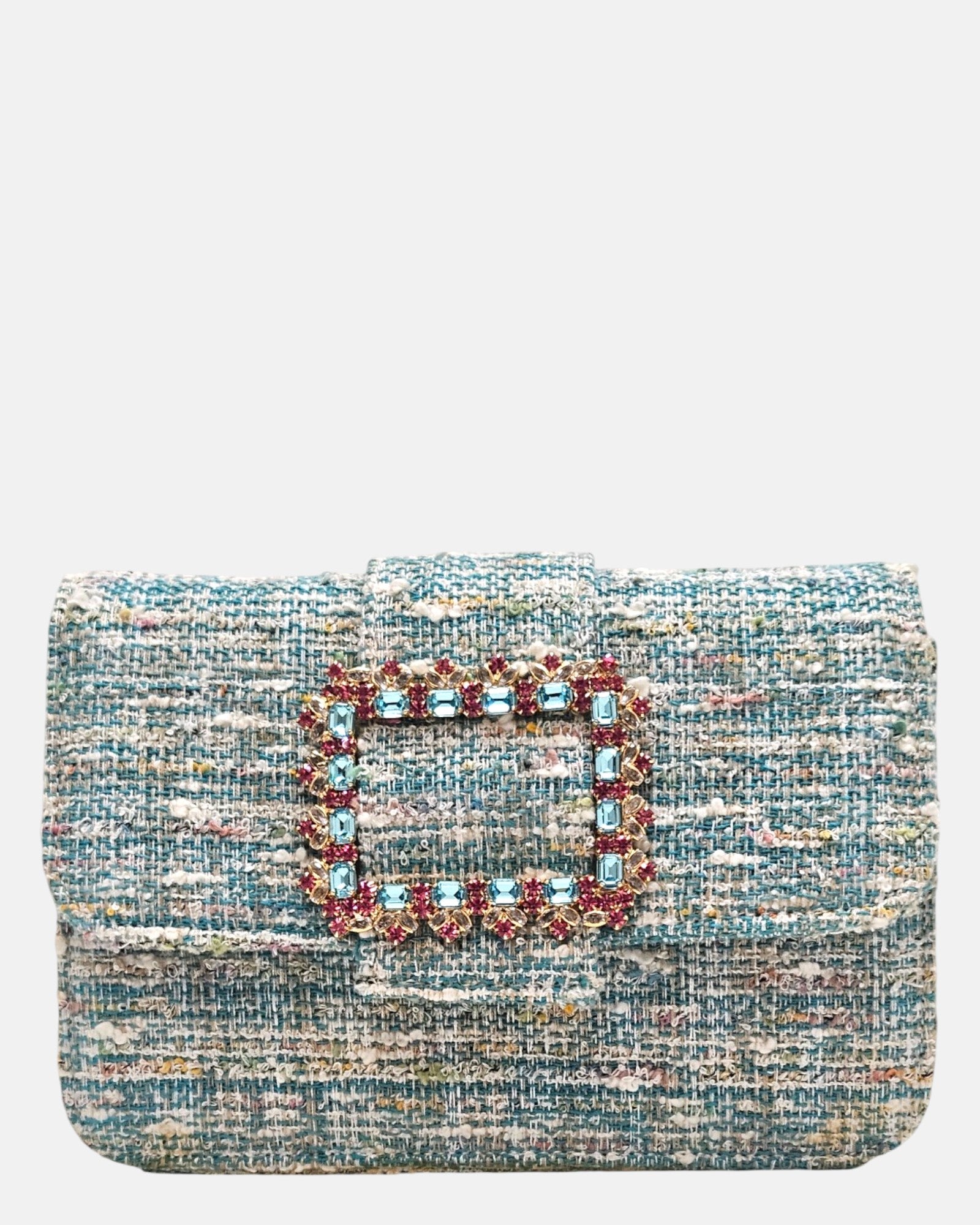 plano frontal de un bolso estructurado de Emanuela Caruso realizado en un elegante tejido jaspeado de tonos azules y verdes, resaltando una gran hebilla dorada central recubierta de piedras de cristal celestes y fucsias.