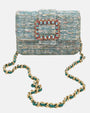 bolso textil de Emanuela Caruso en posición frontal mostrando toda la longitud y caída de su bandolera de eslabones dorados sobre un fondo claro.