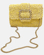 bolso textil de Emanuela Caruso al completo sobre fondo claro, enseñando la caída fluida de su fina bandolera de eslabones dorados brillantes.
