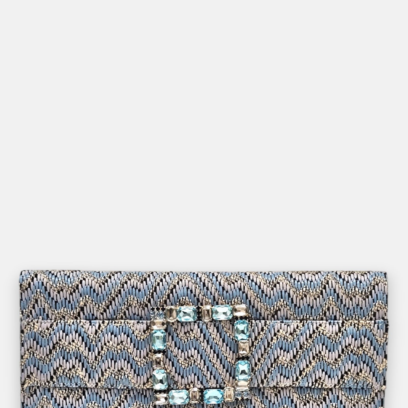 vista frontal de la cartera de mano alargada de Emanuela Caruso con un entramado textil con patrón chevron azul y una gran hebilla rectangular decorada con piedras de cristal en tonos celestes y claros.