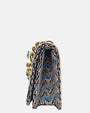 perfil del bolso italiano, revelando su profundo fuelle estructurado de 6 cm, el doblez de la solapa superior y los acabados interiores en tonos azules.