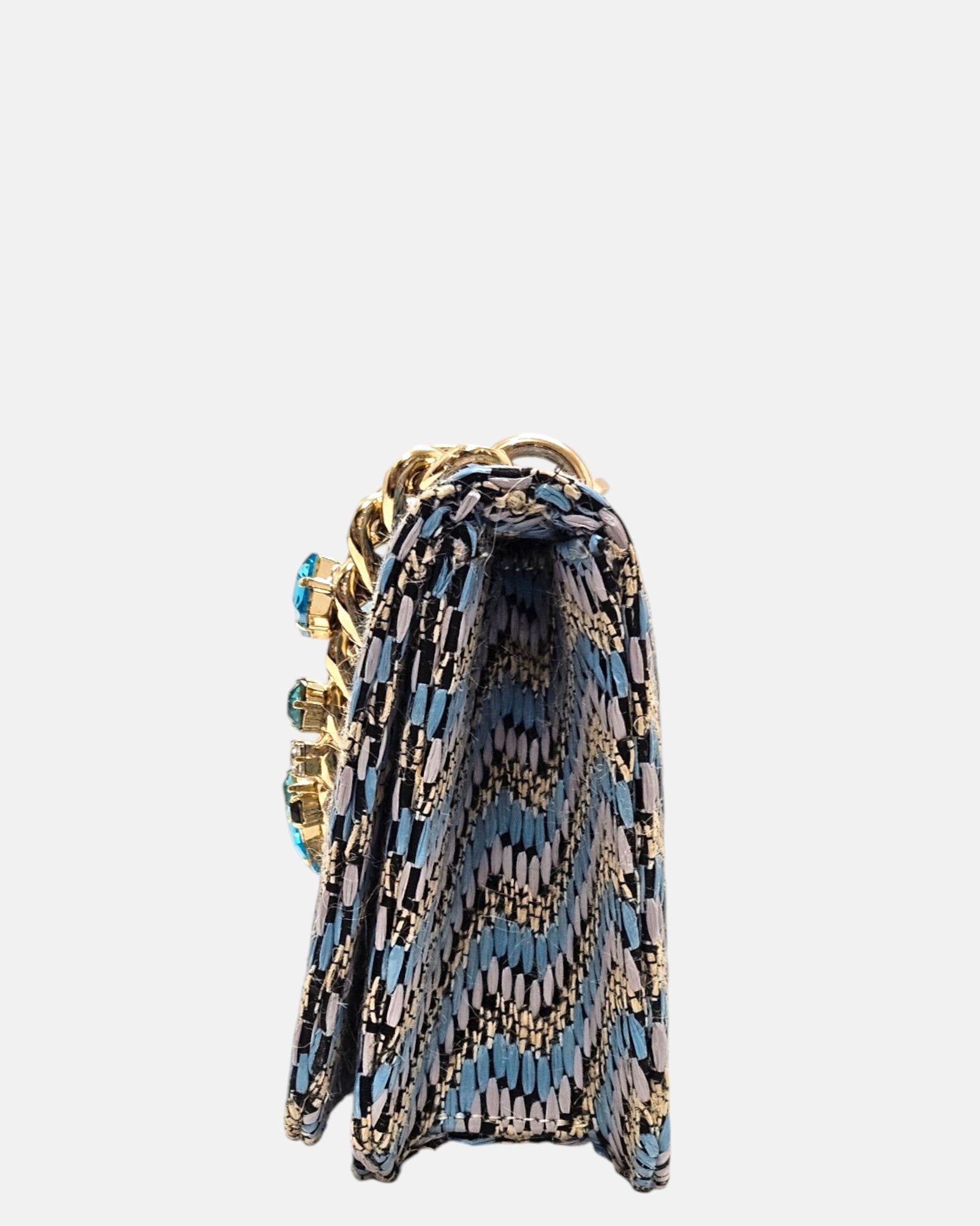 perfil del bolso italiano, revelando su profundo fuelle estructurado de 6 cm, el doblez de la solapa superior y los acabados interiores en tonos azules.