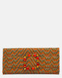 vista frontal de la cartera de mano alargada de Emanuela Caruso con un entramado textil con patrón chevron naranja y una gran hebilla rectangular decorada con piedras de cristal de color naranja y ámbar.
