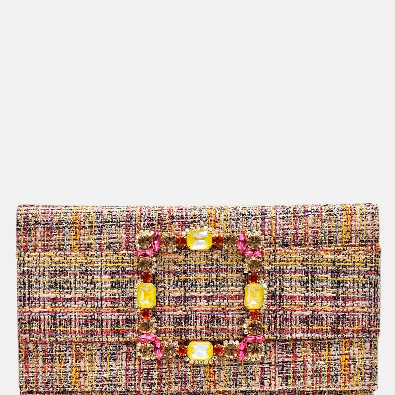 vista frontal de la cartera de mano tipo sobre de Emanuela Caruso con entramado textil multicolor y una gran hebilla rectangular dorada brillante cubierta de piedras de cristal de color amarillo y rosa.