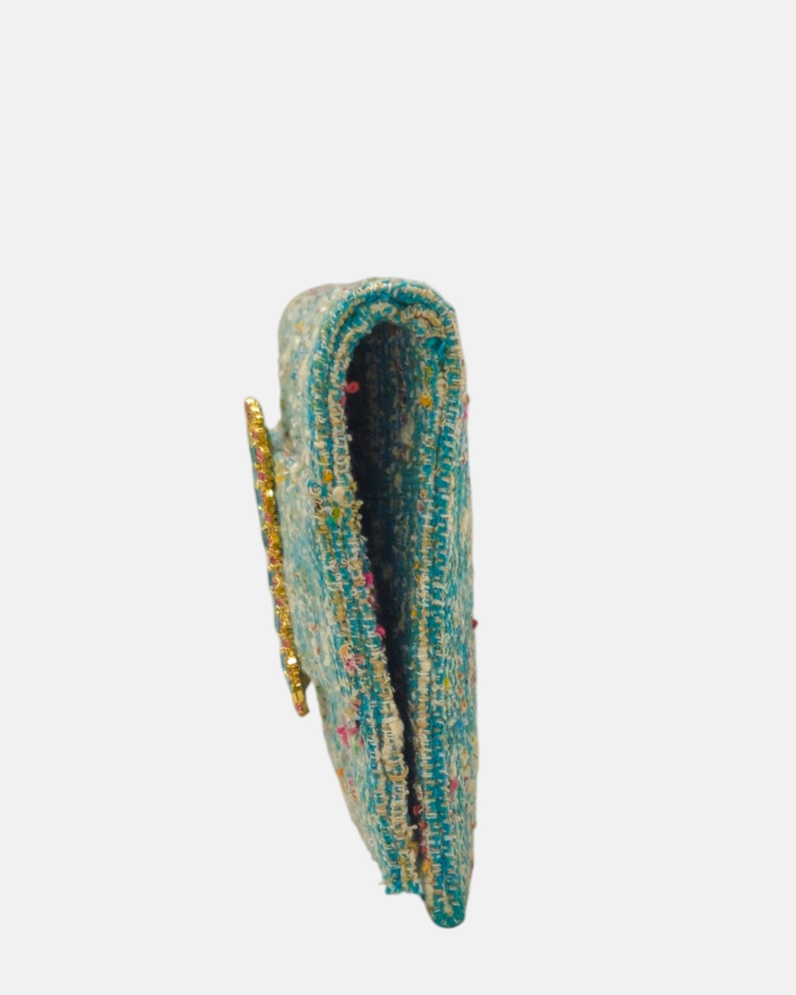 perspectiva de perfil de la cartera italiana, mostrando su silueta delgada tipo clutch con un profundo de 2 cm y el relieve de su broche joya.