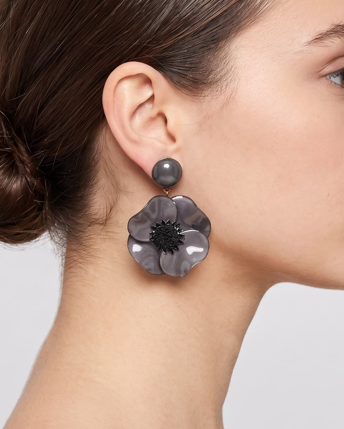 Vista de perfil de los pendientes colgantes de mariposa de Ciléa Paris colocados en una modelo, detallando su volumen maxi y cómo asientan con su cómodo sistema de pinza.