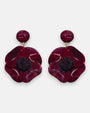 Pareja de pendientes grandes de flor anémona de Ciléa Paris, mostrando sus pétalos rojo borgoña brillantes y su núcleo negro texturizado.