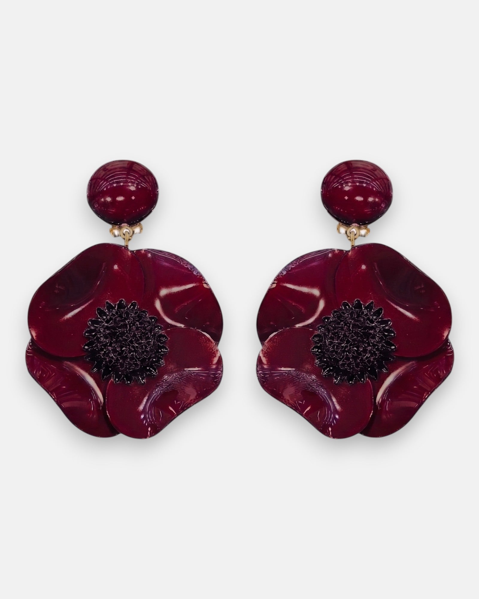 Pareja de pendientes grandes de flor anémona de Ciléa Paris, mostrando sus pétalos rojo borgoña brillantes y su núcleo negro texturizado.