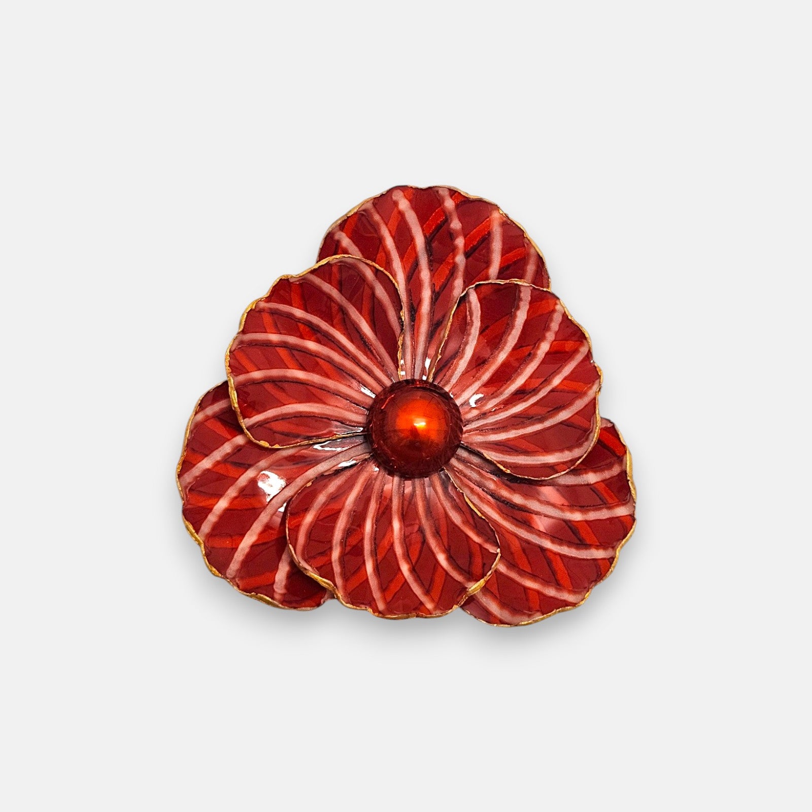 Gran broche maxi en forma de flor camelia de Ciléa Paris, mostrando sus pétalos rojo carmín esmaltados con rayas crema y su centro redondo brillante.