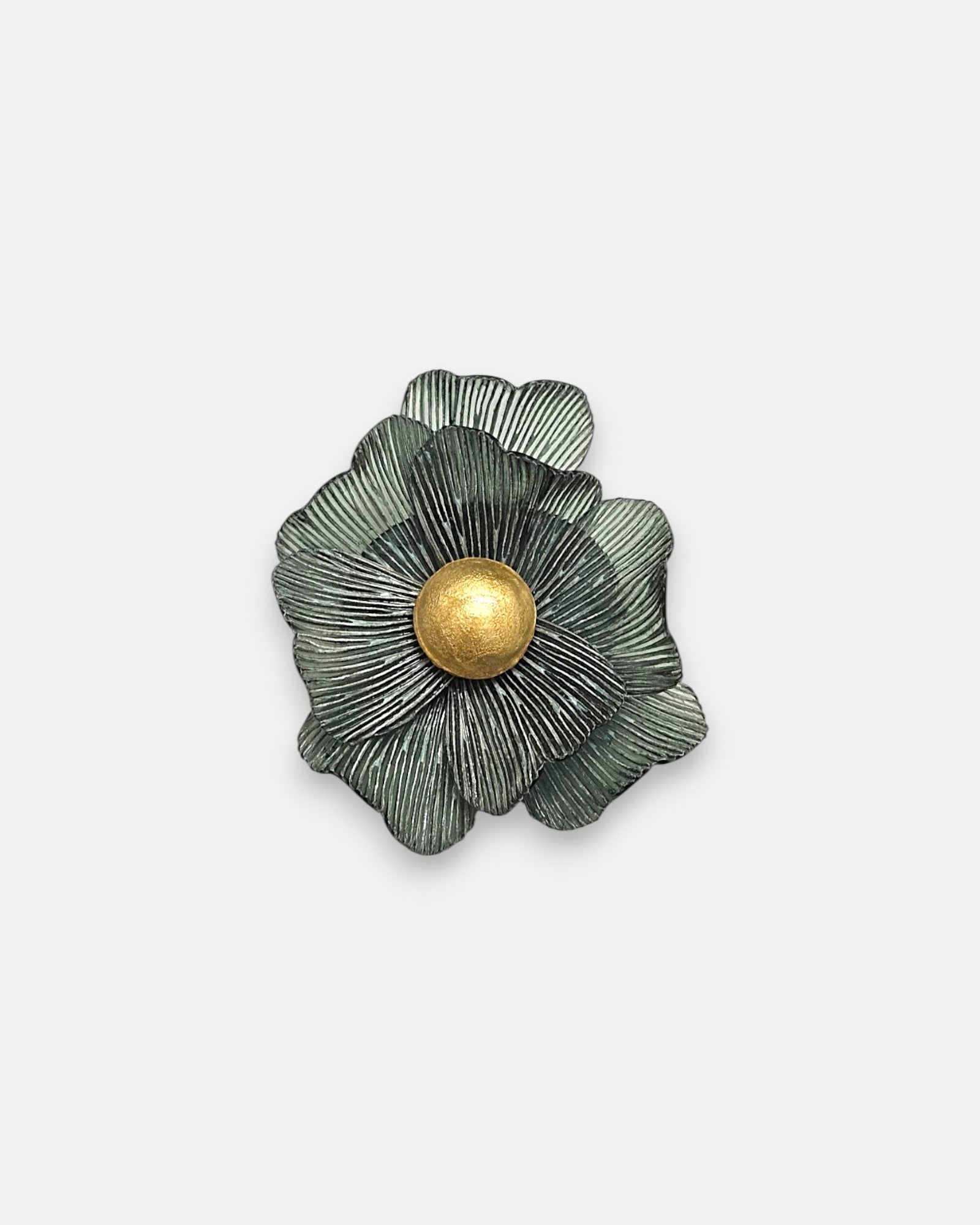 Broche mediano en forma de flor camelia de Ciléa Paris, mostrando sus pétalos verde musgo estriados y su gran botón central esférico en oro viejo.
