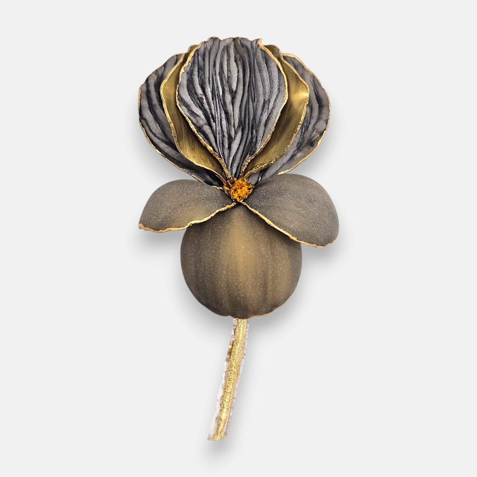 Broche de diseño francés en forma de flor iris de Ciléa Paris, mostrando sus pétalos en gris grafito mate estriado, detalles en oro viejo y tallo dorado.