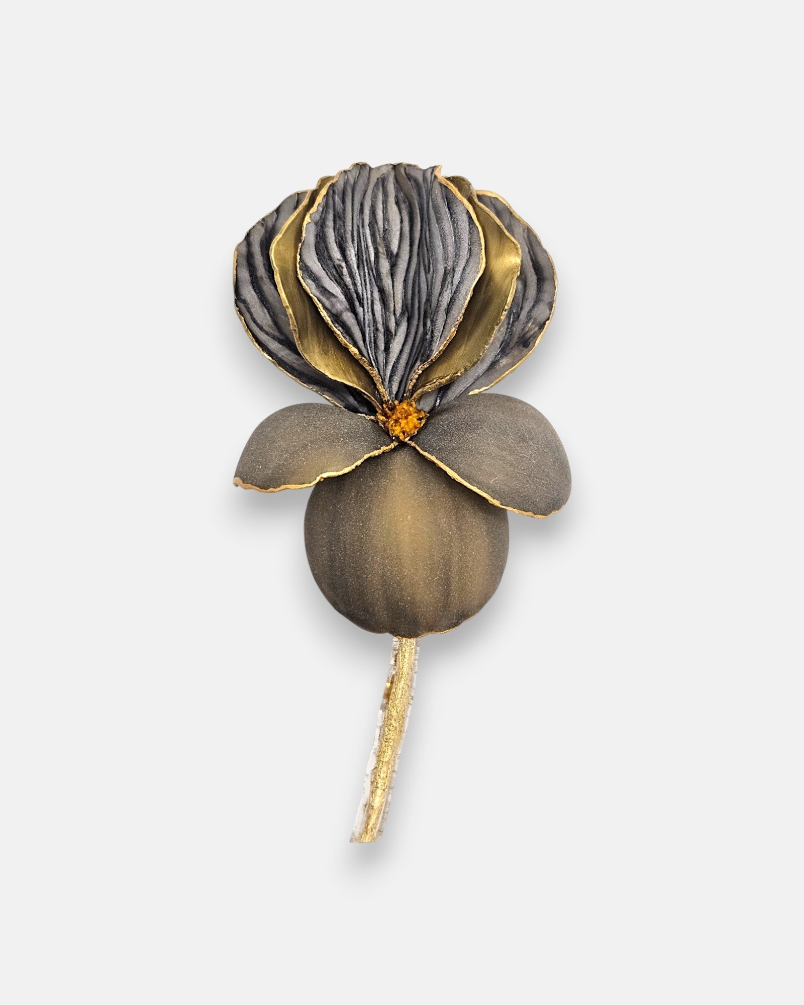 Broche de diseño francés en forma de flor iris de Ciléa Paris, mostrando sus pétalos en gris grafito mate estriado, detalles en oro viejo y tallo dorado.