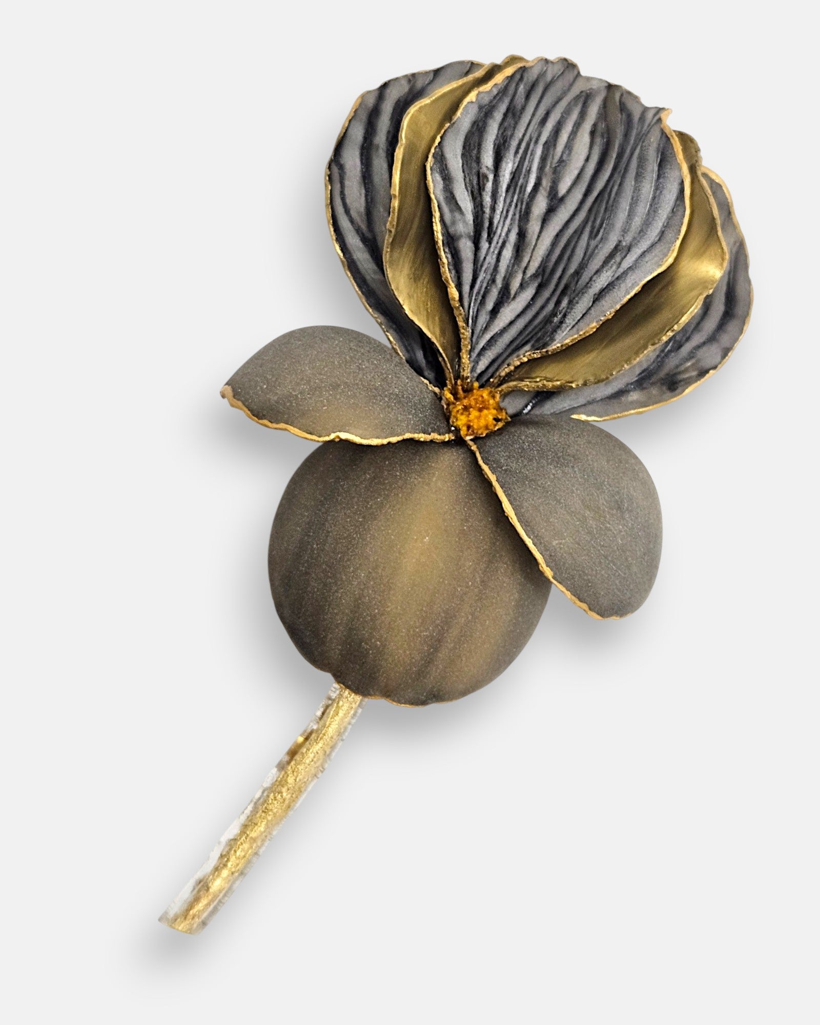Primer plano macro de la flor artesanal de Ciléa Paris, detallando el labrado texturizado de los pétalos gris grafito y los perfiles metalizados en oro viejo.